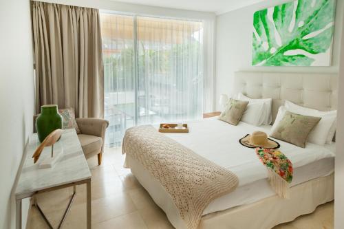a white bedroom with a large bed and a window at Elle Ocean Villa Gran Canaria Heated pool Wifi in Amadores