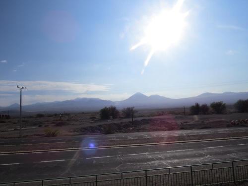 a view of a road with the sun in the sky at Hostal Alabalti in San Pedro de Atacama