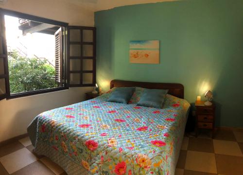 a bedroom with a bed with a colorful comforter and a window at Blue Bay BEACH Villa 25 3-min beach-pool-golf in Blue Bay