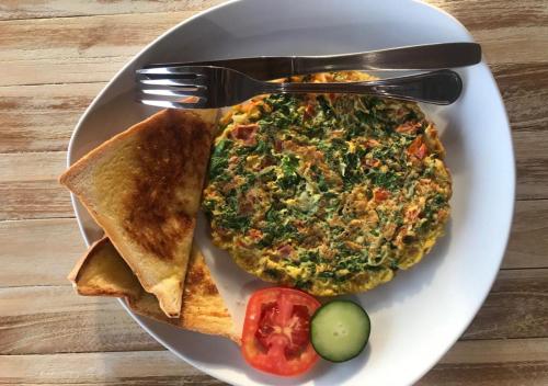 een bord met eten met een pizza bij Daphila Cottage in Nusa Penida