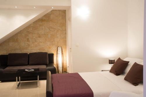 een slaapkamer met een bed en een stoel bij Split Allure Apartments in Split