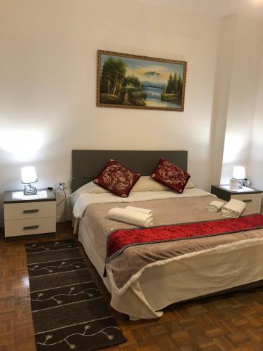 a bedroom with a bed and two tables and a painting at BB Stay Station in Mestre