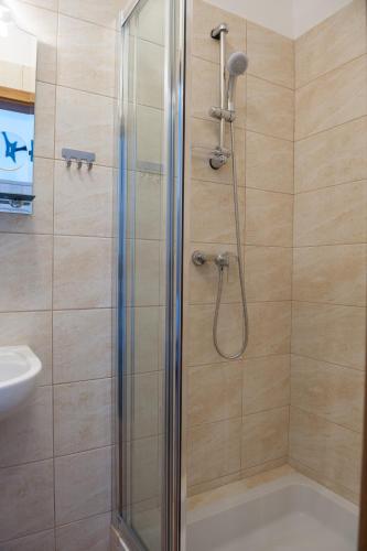 a shower with a glass door in a bathroom at Patra in Warsaw