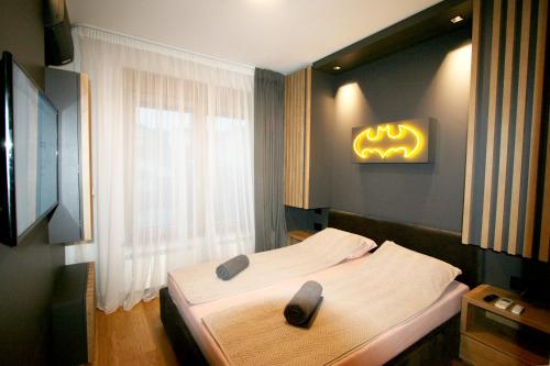 ein Schlafzimmer mit einem Bett mit einem Schild an der Wand in der Unterkunft Apartment Gotham in Belgrad