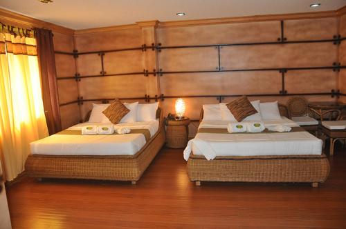 Bosay Resort في أنتيبولو: سريرين في غرفة فندق بسريرين