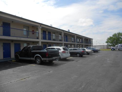 a parking lot with cars parked in front of a building at Executive Inn & Suites - Covington in Covington