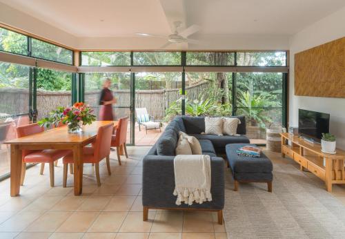 a living room filled with furniture and a large window at The Crest Byron Bay in Byron Bay