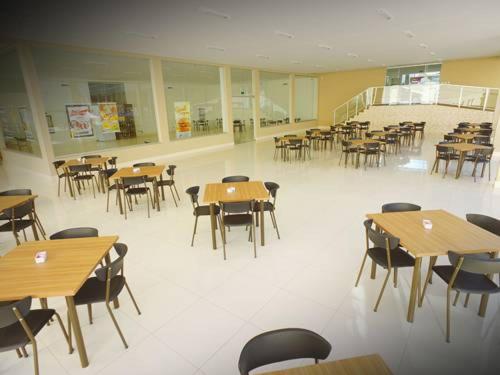 a cafeteria with wooden tables and chairs in a building at Encontro das Águas in Caldas Novas