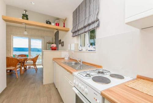a kitchen with a sink and a stove top oven at Apartments Luxury view in Omiš