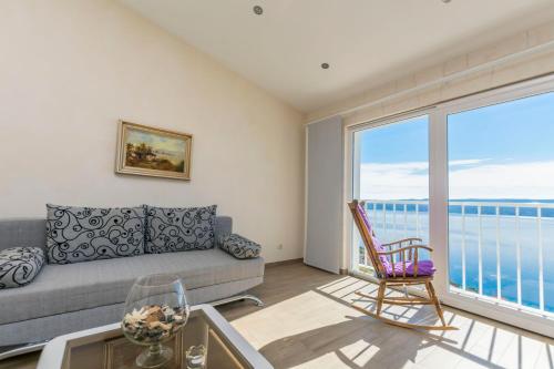 a living room with a couch and a large window at Apartments Luxury view in Omiš