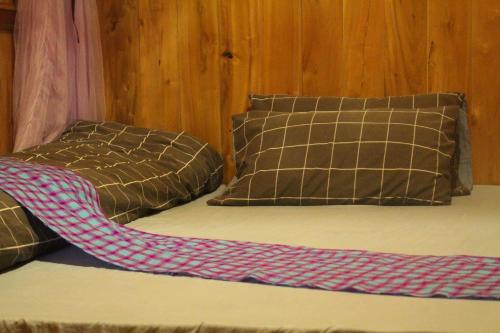 a bed with two pillows and a blanket on it at Sapa Orange Homestay in Sa Pa