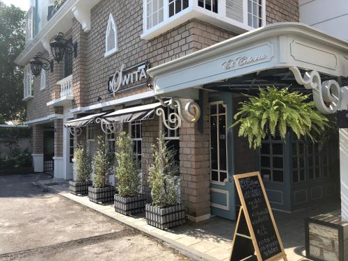 a restaurant with potted plants in front of a building at M. Swita เอ็ม.สวิต in Bangkok