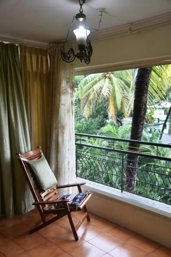 a rocking chair sitting in a room with a window at BEAUTIFUL SPACIOUS STUDIO APT IN CANDOLIM with Wifi in Candolim