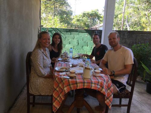 a group of people sitting around a table at Monara Backpacker Inn Unawatuna in Unawatuna