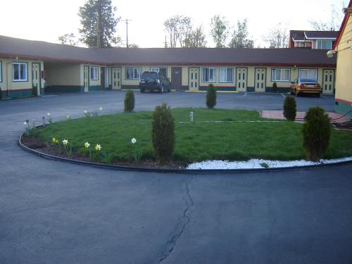 a building with a bunch of flowers in a yard at Bali Hai Motel in Yakima