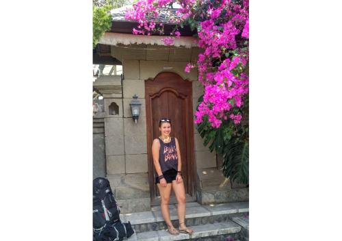 a woman standing in front of a building with flowers at The Dream Home Villas in Denpasar