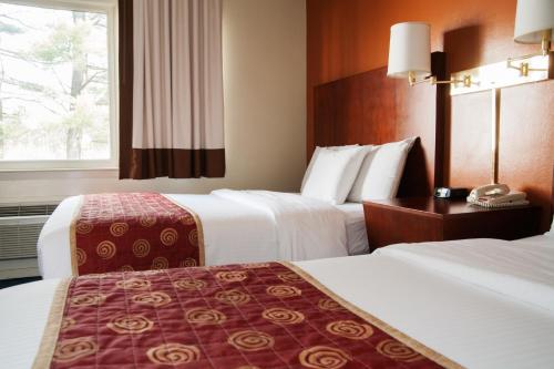 a hotel room with two beds and a window at Red Carpet Inn and Suites Plymouth in Plymouth