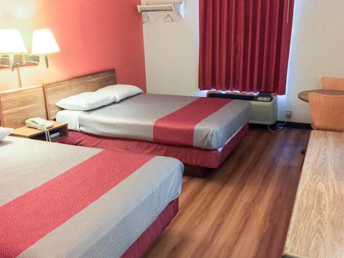 a hotel room with two beds and a red window at Motel 6-Arkadelphia, AR in Arkadelphia
