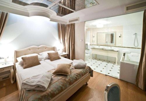 キェルツェにあるGRAND HOTEL Kielceのベッドルーム(大型ベッド1台付)、バスルームが備わります。