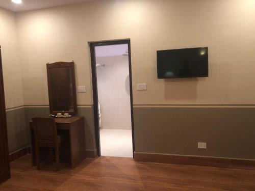 a room with a mirror and a television on the wall at Jungle Safari Resort in Sauraha