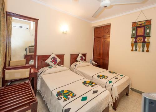 a bedroom with two beds and a mirror at Amanda Hills in Kandy