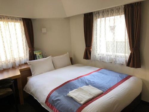 Postel nebo postele na pokoji v ubytování Kawasaki River Hotel