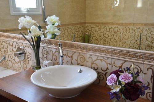 a bathroom with a sink and flowers on a counter at Huge Penthouse with Private Pool in Paphos City
