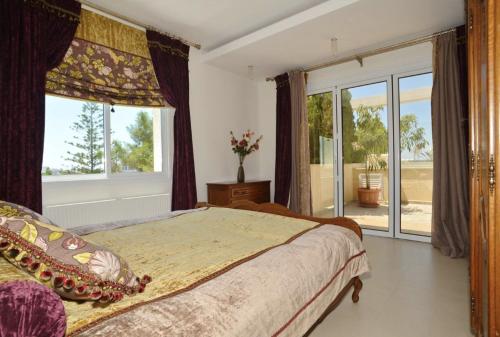 a bedroom with a bed and a large window at Huge Penthouse with Private Pool in Paphos City