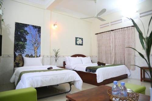 una habitación de hotel con dos camas y una mesa en Panhanita Apartment and Villa, en Siem Reap