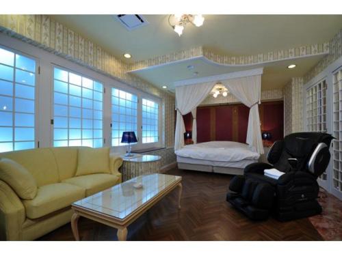 uma sala de estar com um sofá e uma cama em Hotel ShaSha Resort Suma em Kobe
