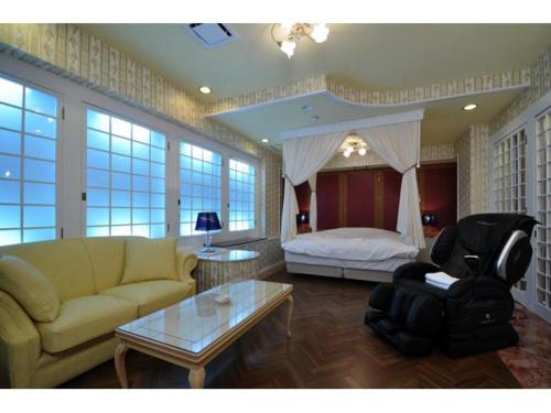 a living room with a couch and a bed at Hotel ShaSha Resort Suma in Kobe