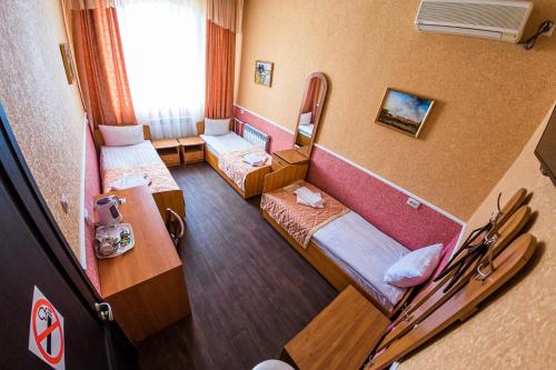 Kleines Zimmer mit 2 Betten und einem Tisch in der Unterkunft Apartment Hotel in Blagoweschtschensk