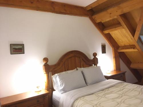 a bedroom with a bed with white sheets and wooden ceilings at Owl Street Lodge in Hope