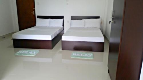 two beds in a small room with towels on the floor at Mahaweli View Inn in Kandy