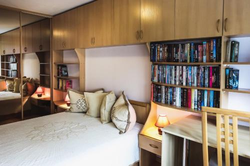 a bedroom with a bed and book shelves with books at Raimondas Apartments in Klaipėda
