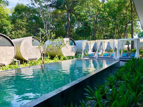 a pool at a resort with blue chairs and water at The Culvert in Kuching