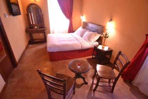 a bedroom with a bed and a table and chairs at Il Casale Di Roma in Prima Porta