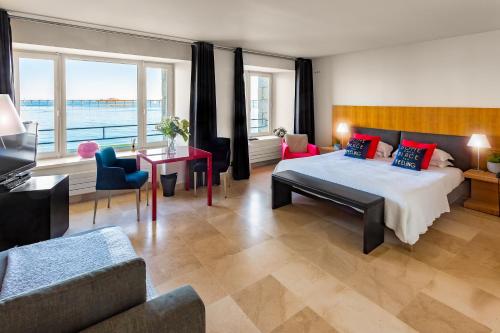 een slaapkamer met een groot bed en een woonkamer bij Hotel Le Temps De Vivre in Roscoff