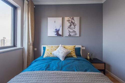 ein Schlafzimmer mit einem blauen Bett und einem Fenster in der Unterkunft Xi'an Yanta·Yongning Gate· Locals Apartment 00135090 in Xi'an