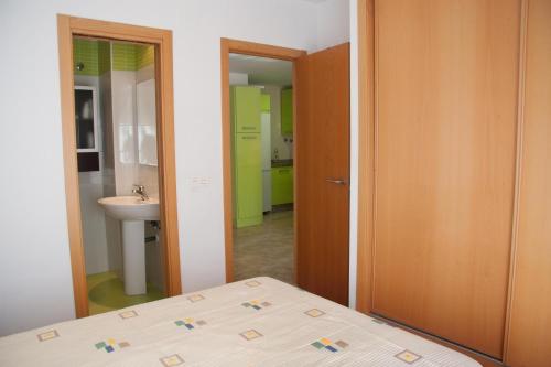 a bedroom with a bed and a bathroom with a sink at APARTAMENTO VERDE La Herradura in Almuñécar