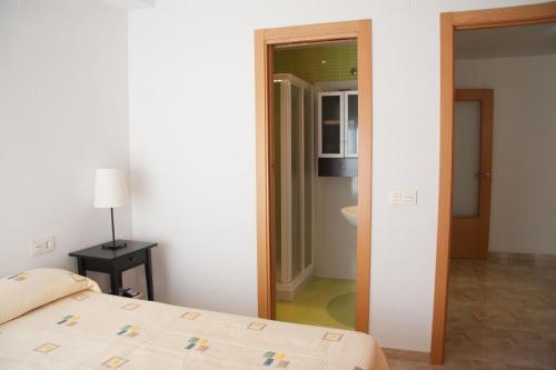 a bedroom with a bed and a door to a bathroom at APARTAMENTO VERDE La Herradura in Almuñécar