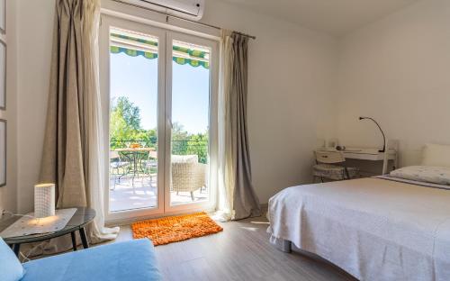 - une chambre avec un lit et un balcon avec une terrasse dans l'établissement Apartman Bellavista, à Pula