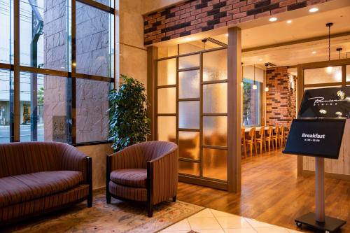 a lobby of a restaurant with two chairs and a table at Hotel Resol Sapporo Nakajima Koen in Sapporo