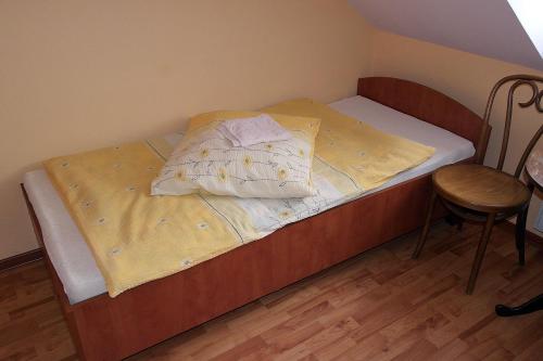 małe łóżko w pokoju z krzesłem w obiekcie Zajazd Skorpion Rzeniszów w mieście Koziegłowy