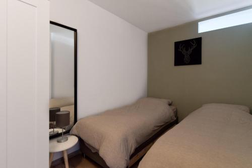 a bedroom with two beds and a mirror at Hightop Apartments Winterberg in Winterberg