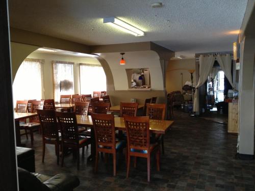 una sala da pranzo con tavoli e sedie in legno di Galaxy Motel a St. Paul