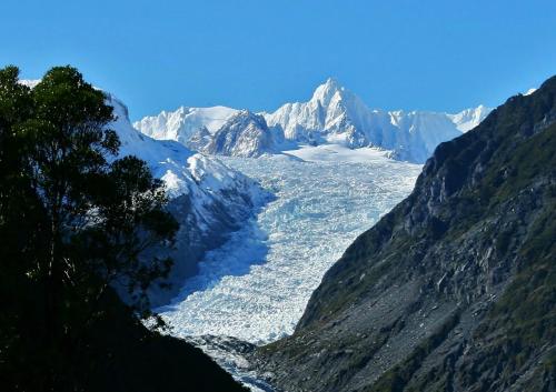 a river in the middle of a snowy mountain at Bella Vista Motel Fox Glacier in Fox Glacier