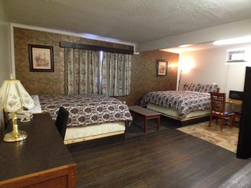 a hotel room with two beds and a desk at Galaxy Motel in St. Paul