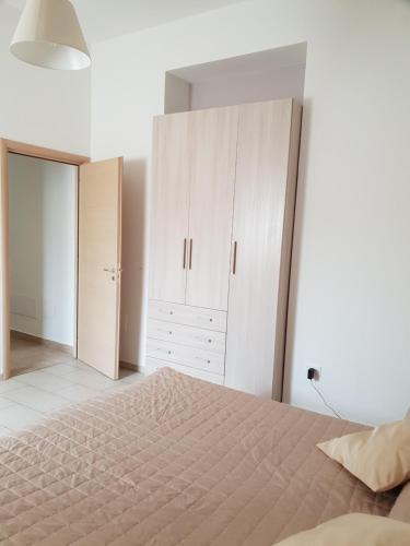 a bedroom with a large bed and white cabinets at Grazioso Appartamento Vacanze The Lighthouse in Paola