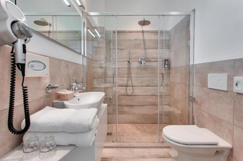 ein Bad mit einer Dusche, einem WC und einem Waschbecken in der Unterkunft Hotel Internazionale in Cesenatico